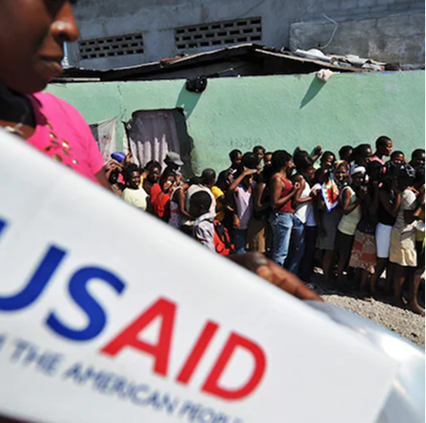 Historic black and white photograph of USAID flag with people